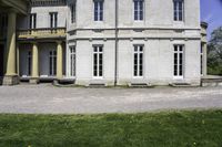 the house is made of stone and has windows and doors, with a black bench in front