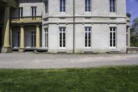 the house is made of stone and has windows and doors, with a black bench in front