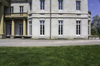 the house is made of stone and has windows and doors, with a black bench in front