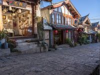 buildings on the side of the street next to a tree with red lanterns at the end