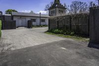 an old farm building with an entrance and gated area that leads to it's yard