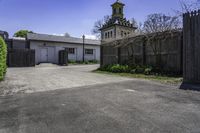 an old farm building with an entrance and gated area that leads to it's yard