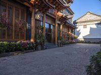 a cobblestone street in front of a building with decorative flowers on the windows