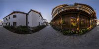 a spherical fish eye photograph of flowers and buildings on a sunny day, shot in a wide angle