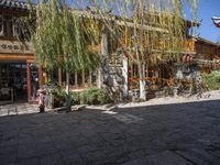 a restaurant on the corner in the town of china with lots of furniture under the tree