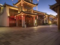 a pagoda sits outside in a building lit up at night and lit up with lanterns