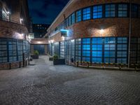 some dark blue windows in an industrial building with no one on the street to the right