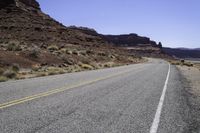 there is a motorcycle on the side of the road with desert in the background and mountains