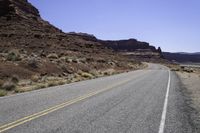 there is a motorcycle on the side of the road with desert in the background and mountains