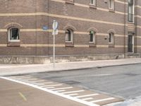 a blue stop sign that is on a street corner near buildings of some sort with windows