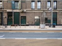 street and sidewalk of two building with parking spaces and bicycle racks in front of them