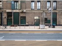 street and sidewalk of two building with parking spaces and bicycle racks in front of them