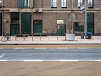 street and sidewalk of two building with parking spaces and bicycle racks in front of them