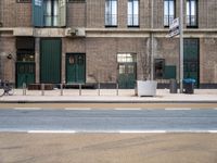 street and sidewalk of two building with parking spaces and bicycle racks in front of them