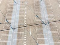 empty parking lot with blue arrows leading from a plane to the terminal with two planes at one end