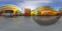 multiple circular angles shows the architecture of a building and skate board park while the sky is blue