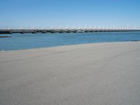 the bridge has two different bridges on it over water or lake side with blue sky in the background