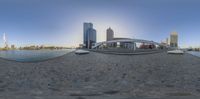 the view of a bridge and buildings on the other side of the water from a fish - eye lens