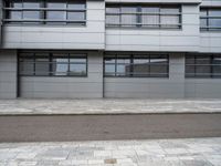 there is a street with white cars parked in front of this building and windows above them