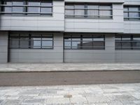 there is a street with white cars parked in front of this building and windows above them