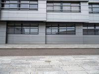 there is a street with white cars parked in front of this building and windows above them