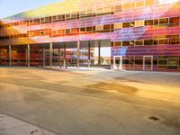 a parking garage has bright glass windows with lights and colors on it it's facade