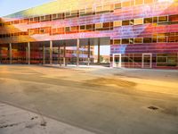 a parking garage has bright glass windows with lights and colors on it it's facade