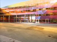 a parking garage has bright glass windows with lights and colors on it it's facade