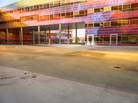 a parking garage has bright glass windows with lights and colors on it it's facade