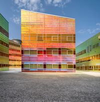 a building with multiple different colors of paint on it and windows that look like they are stacked