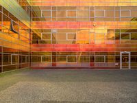 the courtyard area is very colorful with reflective windows and colorful glass walling, as well as