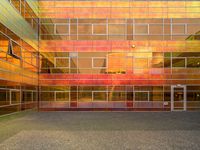 the courtyard area is very colorful with reflective windows and colorful glass walling, as well as