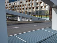 a car traveling down a city street past tall buildings and a long, empty road