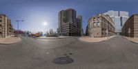 a man riding a skateboard on a street with buildings and cars near by in a 360 - 360 view