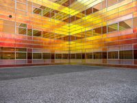 an empty courtyard that has a brightly colored facade in the middle of it, with a stone paved floor