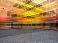 an empty courtyard that has a brightly colored facade in the middle of it, with a stone paved floor