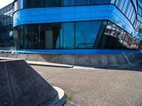 a skateboarder doing tricks in front of a building with many windows on the side