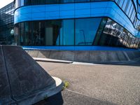 a skateboarder doing tricks in front of a building with many windows on the side