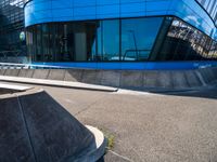 a skateboarder doing tricks in front of a building with many windows on the side