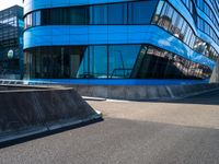 a skateboarder doing tricks in front of a building with many windows on the side