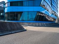 a skateboarder doing tricks in front of a building with many windows on the side