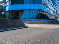 a skateboarder doing tricks in front of a building with many windows on the side