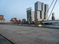 a bicycle parked in front of a bridge and some buildings in the background at dusk