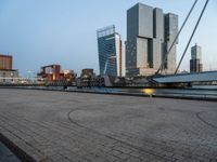 a bicycle parked in front of a bridge and some buildings in the background at dusk