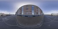 some buildings in the background as seen from a fish eye lensing view of a person in the foreground