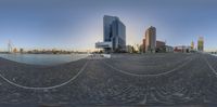 the city skyline reflected in a spherical lens of a harbor and walkway area by the water