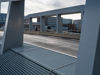 an overpass walkway running on the side of a road surrounded by high rise buildings