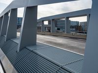 an overpass walkway running on the side of a road surrounded by high rise buildings