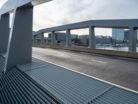 an overpass walkway running on the side of a road surrounded by high rise buildings