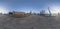 a fish - eye view of a city and the river and bridge from a circle